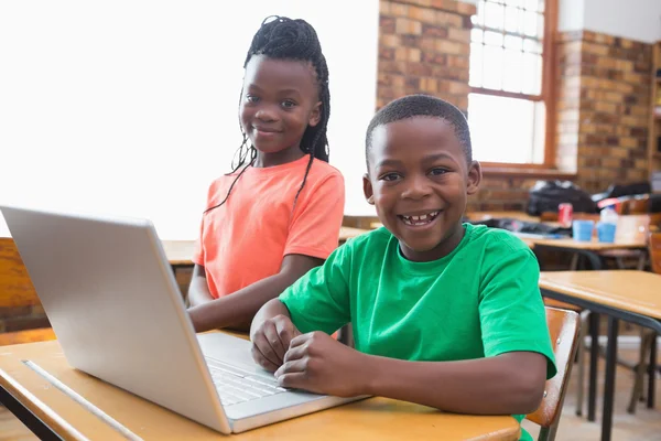 Pupils using laptop in classroom
