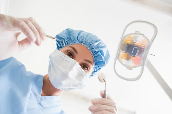 Dentist in surgical mask and cap