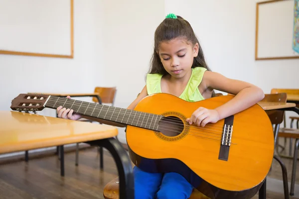 Pupil playing guitar in classroom