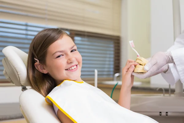 Dentist showing girl teeth model