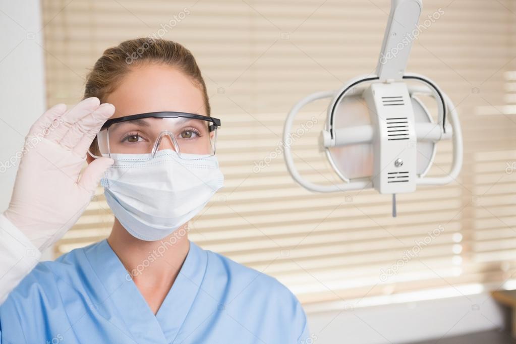 Dentista de mascarilla quirúrgica y gafas protectoras — Fotos de Stock