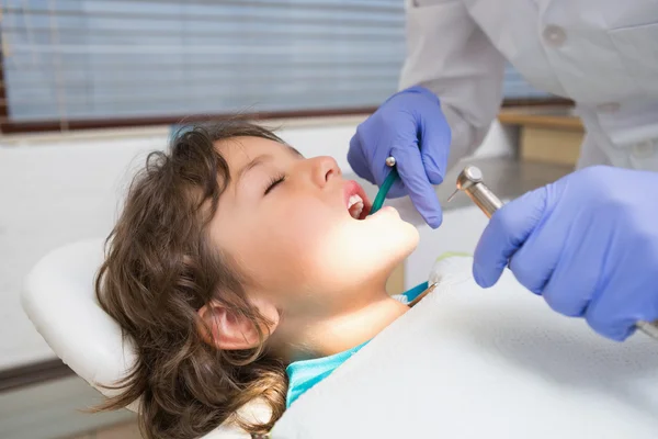 Pediatric dentist examining a little boys teeth in the dentists