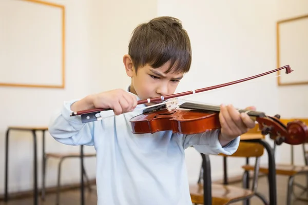 Pupil playing violin in classroom