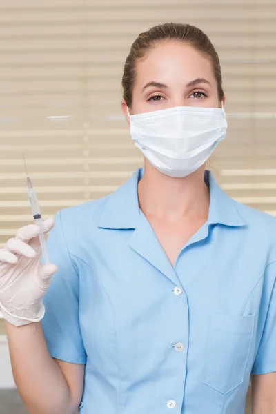 Dental assistant holding injection