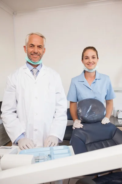 Dentist and assistant smiling