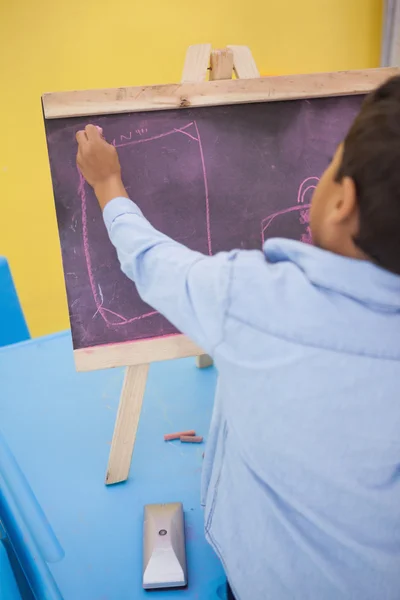 Little boy drawing on chalkboard