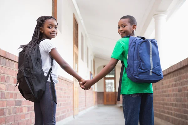 Pupils holding hands in corridor