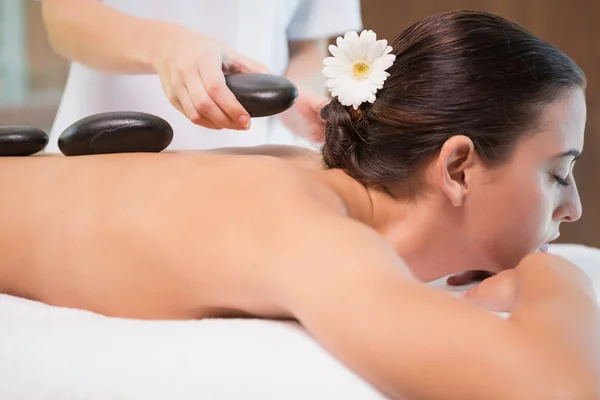 Beautiful woman receiving stone massage at health farm