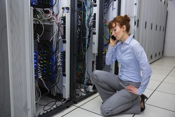 Technician talking on phone while analysing server