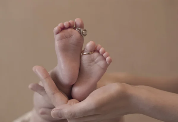 Wedding rings on a tiny baby feet