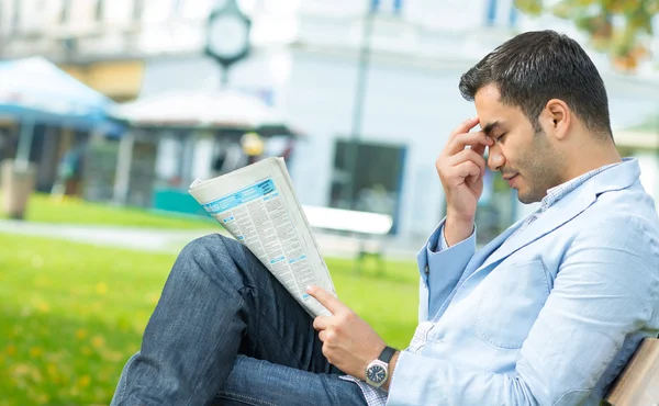 Young man with a headashe holding newspapers