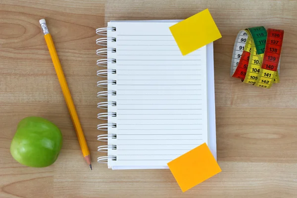 Notebook, green apple, pencil, measuring tape