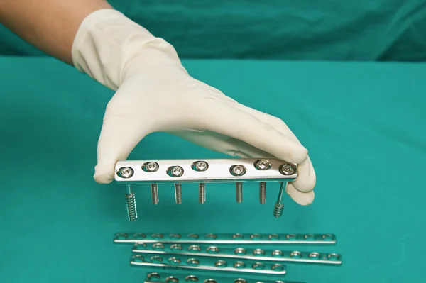 Orthopedic Implant Plates and screw with doctor hand holding o