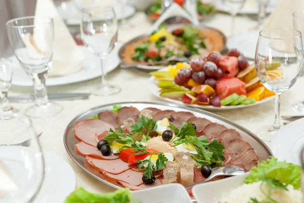 Elegant table setting in restaurant with dishes full of food for celebration