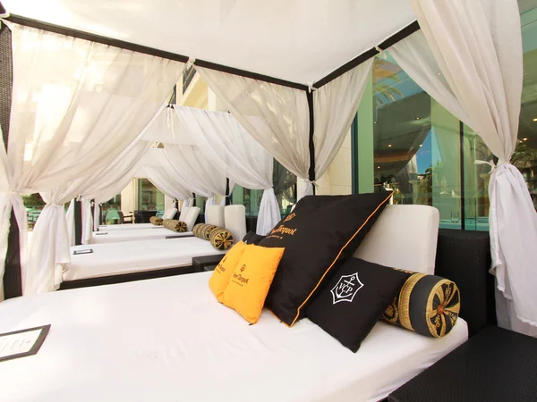 Outdoor bed in a cabana beside a resort pool