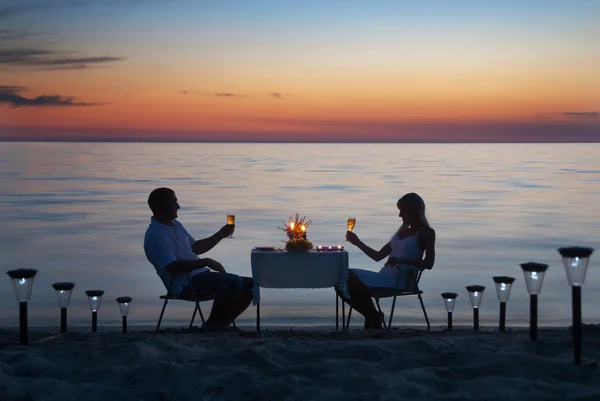 a young couple share a romantic dinner with candles and wine gla
