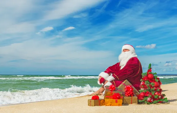 Santa Claus at sea beach with many gifts