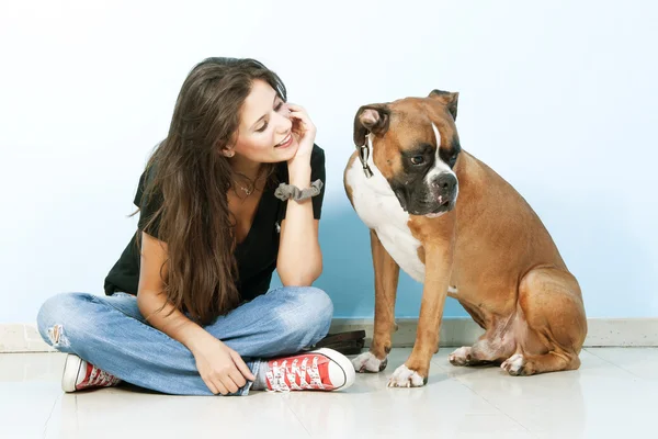 Young woman playing with her dog . Boxer dog.