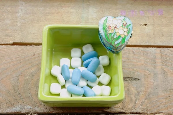 White and blue pills in green pot