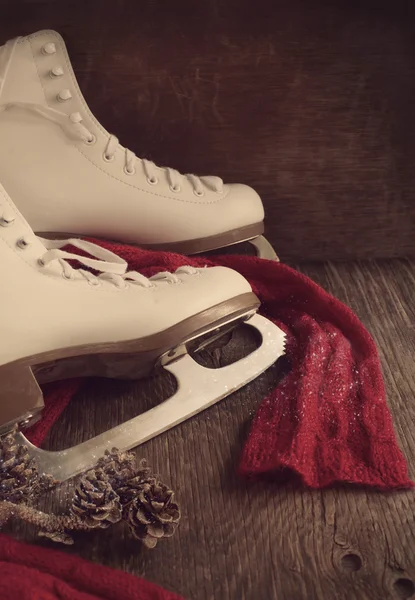 Skates for figure skating on a wooden background, toned