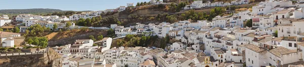 Panoramic photo overviewing pueblo blanco Setenil de las Bodegas. Old white village. Blue sky. Cadiz. Andalusia. Spain.