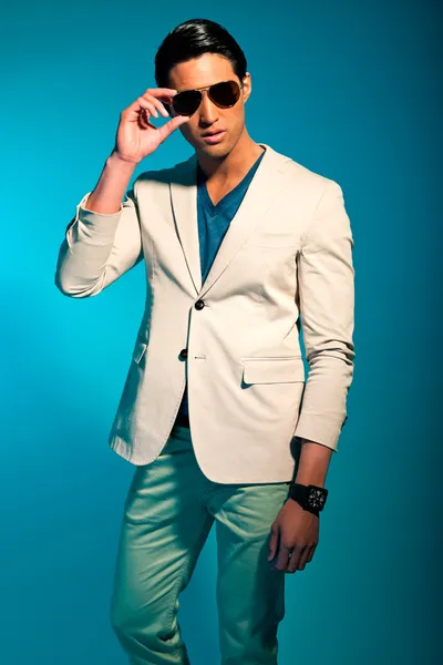 Asian man wearing suit and sunglasses. Summer fashion. Studio.
