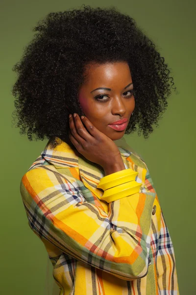 Afro woman in vintage seventies fashion style. Yellow jacket and