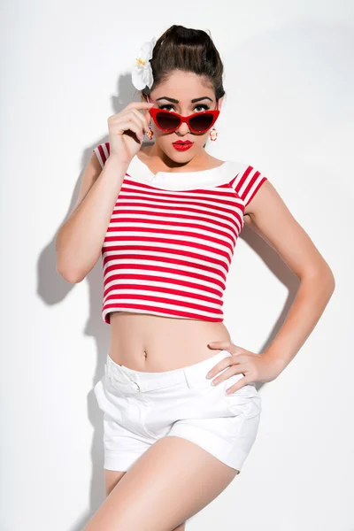 Sexy retro pin-up girl with sunglasses and red lipstick wearing