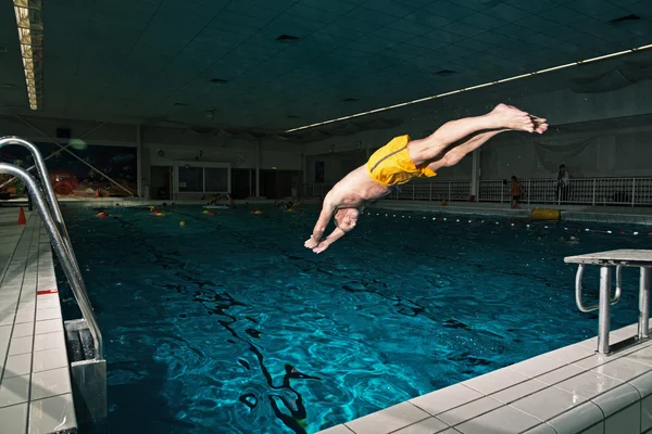 Healthy active senior man with beard in indoor swimming pool div