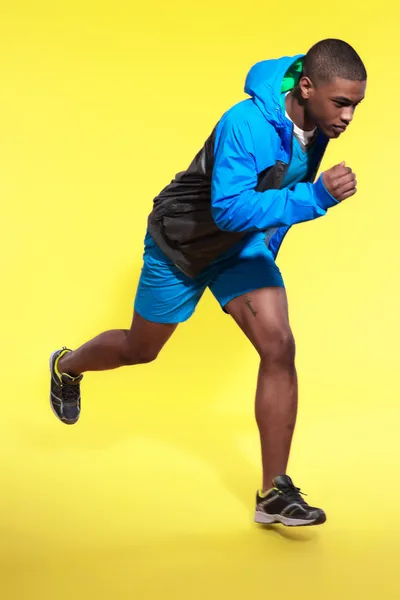 Jumping athletic black man in sportswear fashion. Runner with ho