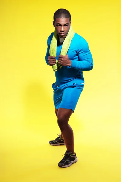 Athletic black man in sportswear fashion. Runner with towel. Int