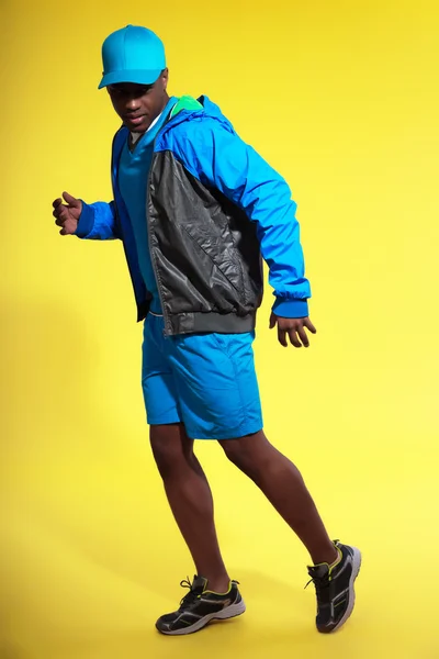 Athletic black man in sportswear fashion. Runner with jacket and