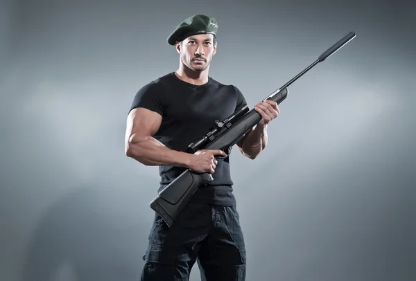 Commander muscled action hero man with rifle wearing black t-shi