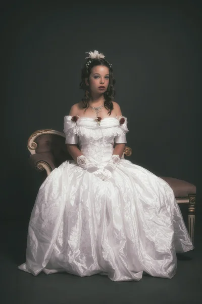 Retro victorian fashion woman wearing white dress. Sitting on an