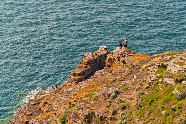 Tourists walking on rocks near ocean. Top view.