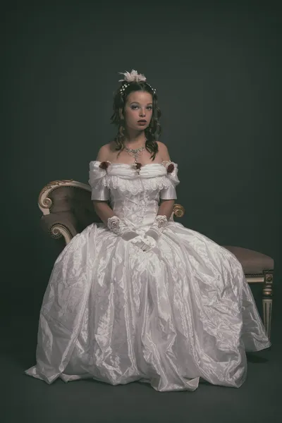 Retro victorian fashion woman wearing white dress. Sitting on an