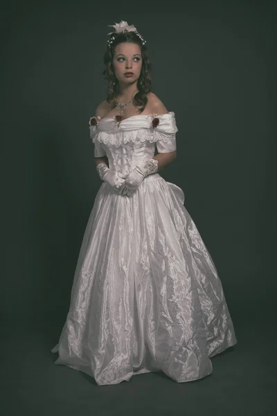 Victorian fashion woman wearing white dress. Studio shot against