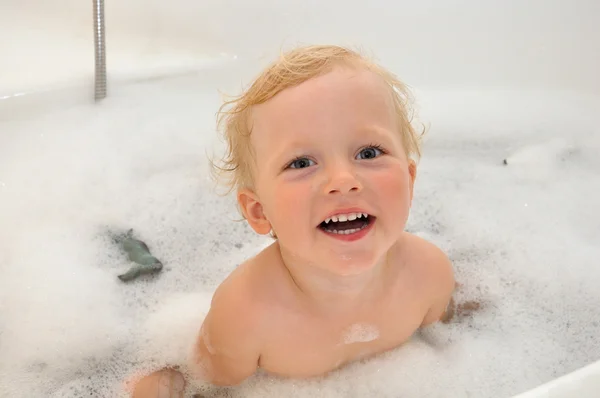 Happy child in soap foam