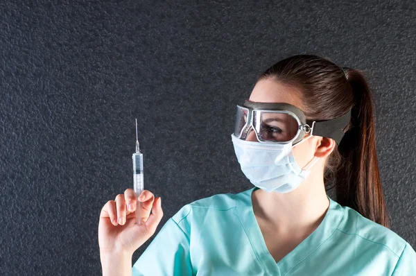Nurse or doctor in pilot glasses with syringe and mask