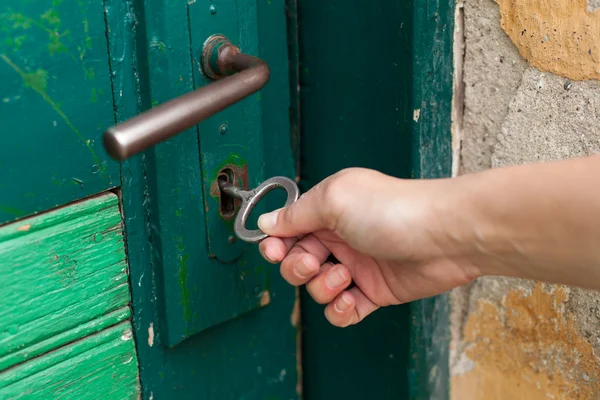 Hand open old door with old key