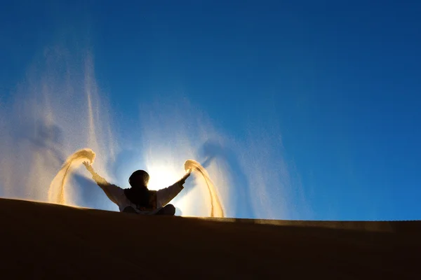 Berber playing and throwing with sands in Desert Sahara, creatin