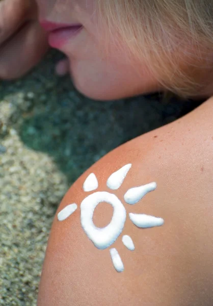 Sun from sun-protection cream on a shoulder at the girl