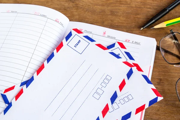 White vintage envelope,notebook on a wood floor