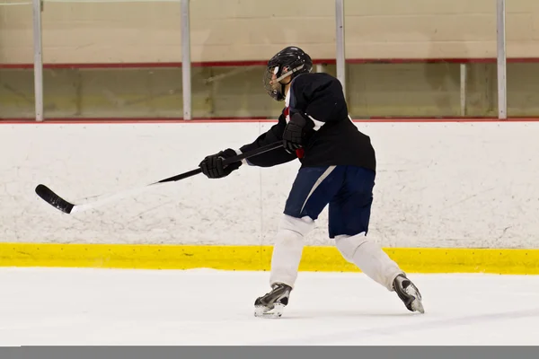 Hockey player takes a slap shot during a game
