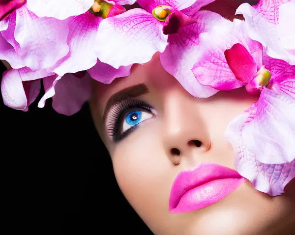 Beautiful girl with flowers and perfect makeup