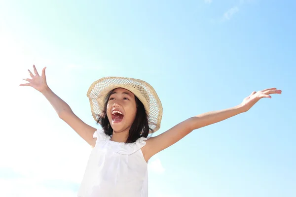 Girl raises her hands against blue sky