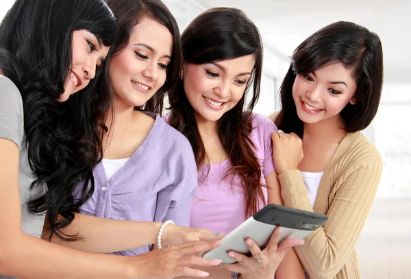 Women friends at home using tablet computer