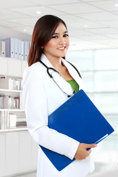 Female doctor in lab coat holding clipboard