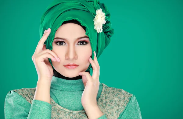 Fashion portrait of young beautiful muslim woman with green cost