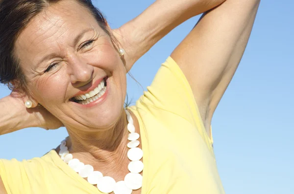 Cheerful senior woman sky background